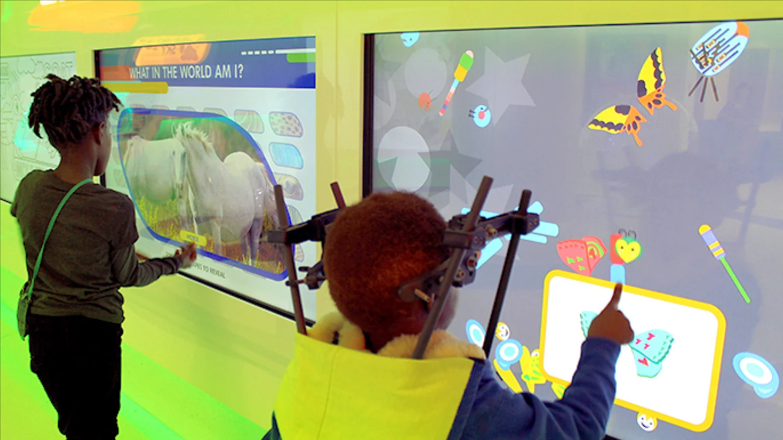 Two children playing across the interactive wall once the room opened